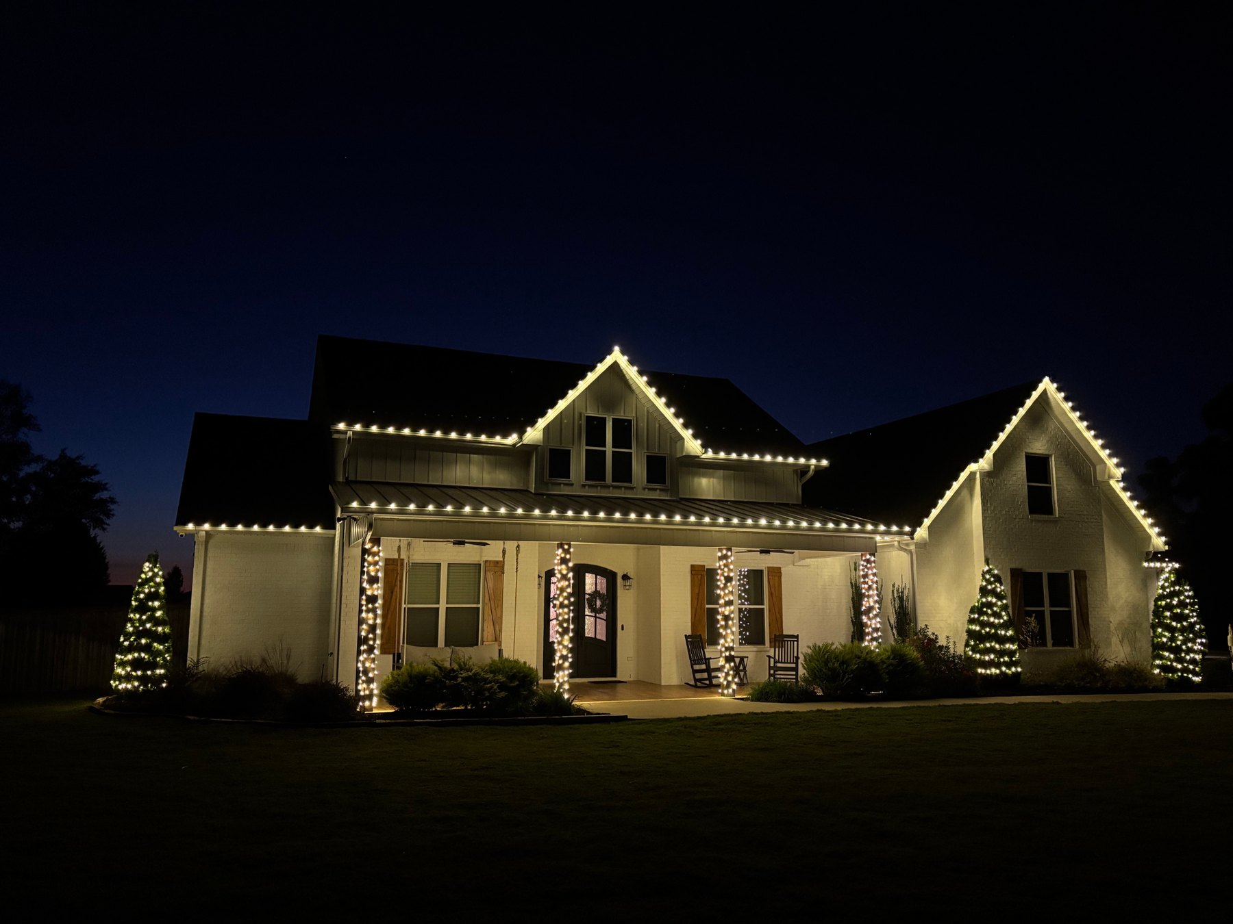 Warm white holiday lighting outlining a large two-story home